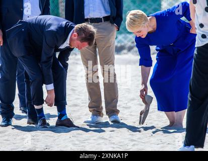 Rostock, Germania. 1 agosto 2024. Manuela Schwesig (SPD), Ministro Presidente del Meclemburgo-Pomerania occidentale, e il suo omologo sassone Michael Kretschmer (CDU) si tolgono le scarpe sulla spiaggia del Mar Baltico e camminano a piedi nudi fino all'acqua. I due governi statali firmano un accordo per una migliore cooperazione nel settore del turismo. Crediti: Jens Büttner/dpa/Alamy Live News Foto Stock