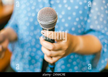 Primo piano mano che tiene in mano un microfono, messa a fuoco selettiva Foto Stock