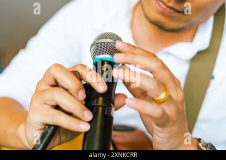 Primo piano mano che tiene in mano un microfono, messa a fuoco selettiva Foto Stock
