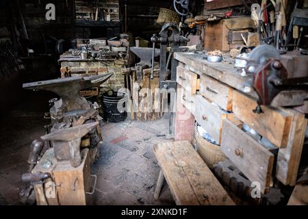 LURAY, Virginia, Stati Uniti - il negozio di fabbro presso lo Shenandoah Heritage Village si erge come un esempio conservato di artigianato del XIX secolo. Originariamente costruita intorno al 1850 con tronchi di castagno, questa struttura storica è stata trasferita dalla piantagione Lee di Lynchburg, Virginia, al suo sito attuale a Luray. Il negozio espone i tradizionali strumenti e tecniche di lavorazione del ferro utilizzati nella valle dello Shenandoah durante gli anni '1800 Foto Stock