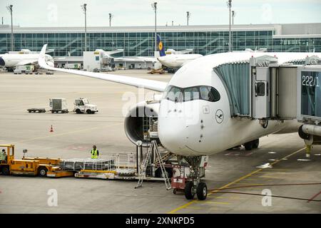 Baviera, Germania - 12 luglio 2024: Un aereo della Lufthansa si trova al cancello di un aeroporto, pronto per l'imbarco *** Ein Lufthansa-Flugzeug steht am Gate eines Flughafens, bereit für das Boarding Foto Stock