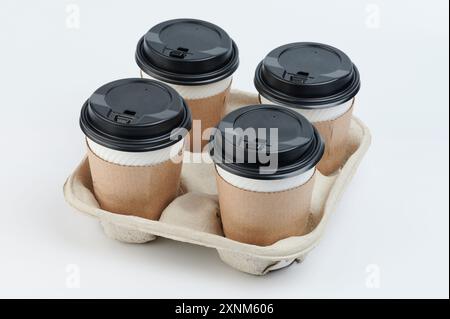 Set di bicchieri di carta con coperchi per bevande calde in vassoio isolato Foto Stock