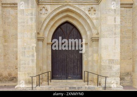 Esterno di una vecchia chiesa cristiana con porte in legno e pareti in mattoni di pietra Foto Stock