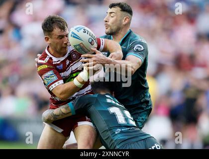 Harry Smith (a sinistra) dei Wigan Warriors viene affrontato dai giganti di Huddersfield Thomas Deakin e Jake Connor (a destra) degli Huddersfield Giants durante il Betfred Super League match al Brick Community Stadium di Wigan. Data foto: Giovedì 1 agosto 2024. Foto Stock