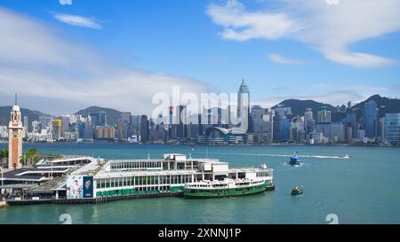 Lo Star Ferry sul Victoria Harbour in una giornata di sole con lo skyline di Hong Kong sullo sfondo. Hong Kong - 12 giugno 2024 Foto Stock