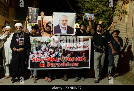 I musulmani sciiti del Kashmir tengono candele, fotografie di Ismail Haniya e uno striscione che dice "Stop Shia Genocide in Parachinar" mentre gridano slogan pro-Palestina e anti-Israele durante una veglia a lume di candela. Una veglia a lume di candela si tenne alla periferia di Srinagar in seguito all'assassinio di Ismail Haniya, il leader politico di Hamas, ucciso in un attacco aereo prealba a Teheran, la capitale dell'Iran. Sia l’Iran che Hamas hanno incolpato Israele dell’assassinio, che comporta il rischio di un’escalation in un conflitto regionale più ampio. Il leader supremo dell'Iran ha promesso vendetta contro Israele. Il Foto Stock