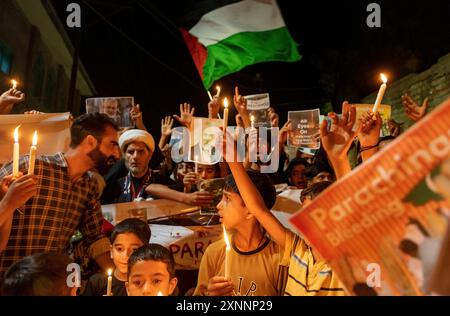 I musulmani sciiti del Kashmir tengono candele e cartelli mentre camminano durante una veglia a lume di candela. Una veglia a lume di candela si tenne alla periferia di Srinagar in seguito all'assassinio di Ismail Haniya, il leader politico di Hamas, ucciso in un attacco aereo prealba a Teheran, la capitale dell'Iran. Sia l’Iran che Hamas hanno incolpato Israele dell’assassinio, che comporta il rischio di un’escalation in un conflitto regionale più ampio. Il leader supremo dell'Iran ha promesso vendetta contro Israele. La protesta non è solo una risposta all'assassinio di Haniya, ma anche una reazione alle uccisioni mirate di Shia Mus Foto Stock