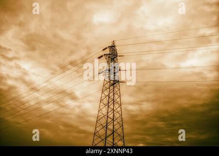 La torre della linea Поwer si erge a picco su un cielo vivace al tramonto. Linee elettriche al tramonto. Foto Stock