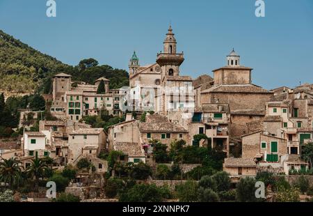 La città presenta una tradizionale architettura europea con case in pietra, tetti in terracotta e persiane verdi, creando una scena bella e senza tempo. Foto Stock