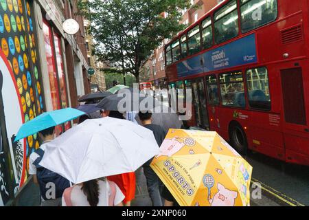 Tempo britannico, Londra, 1 agosto 2024: Dopo diversi giorni di caldo tempeste di tuoni si sono insinuate nel sud dell'Inghilterra e i marciapiedi del West End sono stati improvvisamente riempiti di ombrelli. Crediti: Anna Watson/Alamy Live News Foto Stock