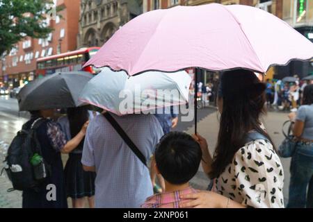 Tempo britannico, Londra, 1 agosto 2024: Dopo diversi giorni di caldo tempeste di tuoni si sono insinuate nel sud dell'Inghilterra e i marciapiedi del West End sono stati improvvisamente riempiti di ombrelli. Crediti: Anna Watson/Alamy Live News Foto Stock