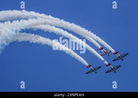 Symbolbild Kunstflugshow, vier Flugzeuge, formazione, Kondensstreifen, blauer Himmel, präzises Fliegen, rote und weiße Lackierung, beeindruckende Flugmanöver, Luftakrobatik, aufregendes Spektakel, Flugshow, lavoro di squadra, Luftfahrtenthusiasten, Flugkünste, Dyische Vorführung, hoher Schwierigkeitsgrad, öffentliche Veranstaltung, Freizeitaktivität, Pilotenfähigkeiten, Aeroshell *** spettacolo acrobatico con immagini simboliche, quattro aerei, formazione, contraglie, cielo blu, volo preciso, livrea rossa e bianca, impressionanti manovre di volo, acrobazie aeree, spettacolo emozionante, spettacolo aereo, lavoro di squadra, aviazione enthus Foto Stock