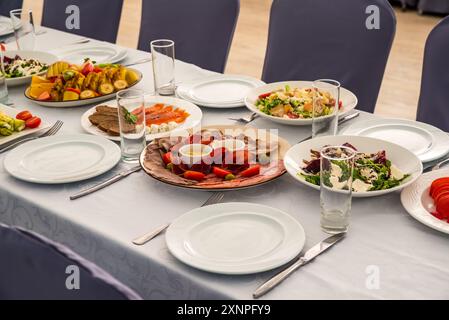 Tavolo festivo con insalate Caesar, barbabietole, piatto di frutta senza persone Foto Stock