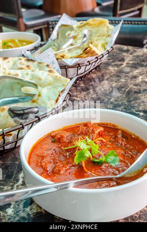 Lamb Rogan Josh, un curry ispirato alla cucina indiana per pranzo in un ristorante. Foto Stock