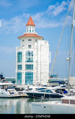 Il moderno faro sorge alla fine del porticciolo di Straits Quay a Tanjung Tokong a Penang, Malesia, con barche da diporto ormeggiate di fronte. Foto Stock