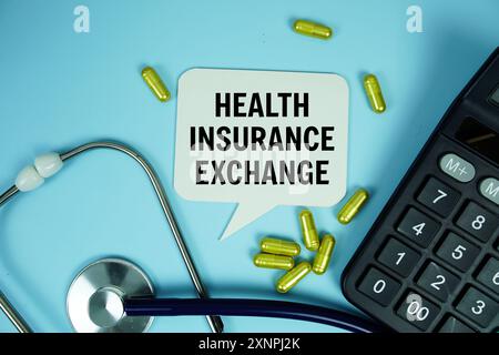 Assicurazione sanitaria Scambio testo con calcolatrice, stetoscopio e capsule medicina su sfondo blu, concetto di salute e benessere Foto Stock