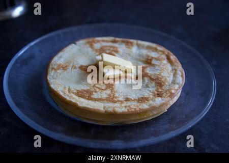 Una pila di pancake con burro sopra Foto Stock