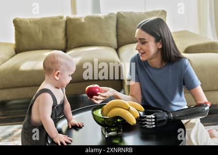 La giovane donna con protesi mette i frutti con il bambino Foto Stock