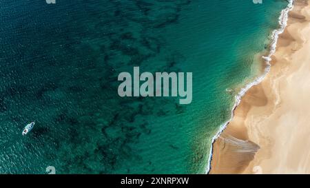 Vista aerea con droni della spiaggia dorata vuota con barca Foto Stock