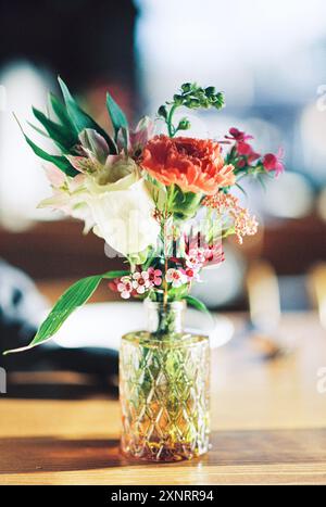 Delicato bouquet di fiori misti in un vaso di vetro vintage. Foto Stock