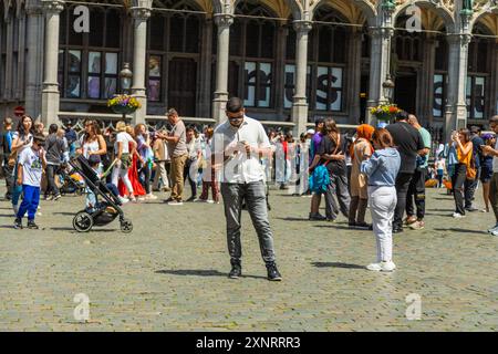 Le persone controllano i messaggi e scattano foto con i telefoni cellulari. Bruxelles Foto Stock