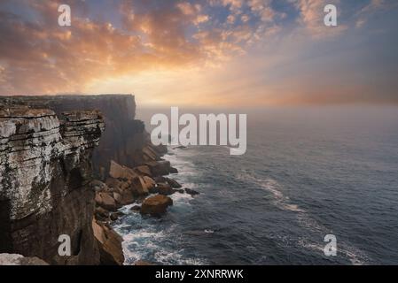 Spettacolare scogliera costiera al tramonto con formazioni rocciose robuste in Portogallo Foto Stock