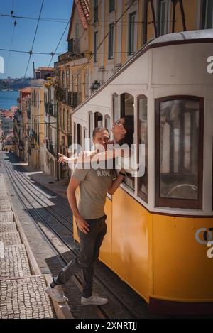 Coppia che si gode un giro su un classico tram giallo a Lisbona, Portogallo Foto Stock