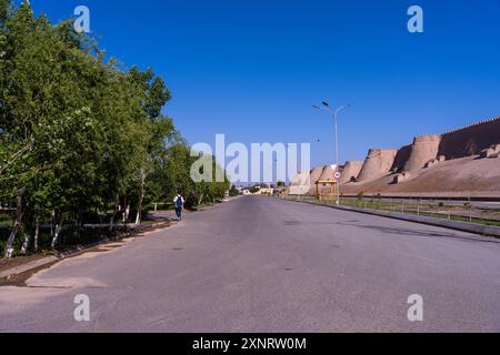 Una strada con qualche albero e un edificio sullo sfondo Foto Stock