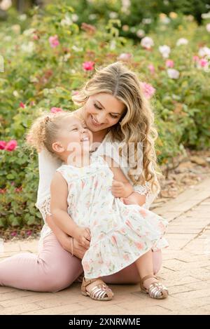 Madre e figlia ridono in giardino Foto Stock