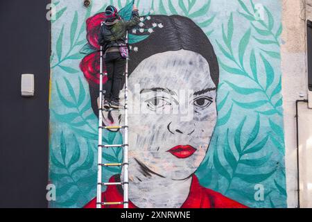 Londra, Regno Unito - 25 gennaio 2024 - artista murale che lavora su un ritratto di Frida Kahlo a London Field Foto Stock