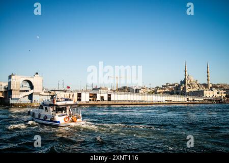 Una vista accattivante dello storico Ponte Galata di Istanbul, con yacht ormeggiati in primo piano, che mostrano la miscela di moderna attività marittima a. Foto Stock