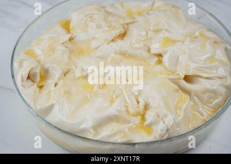 Torta greca con spinaci e salmone in pasta fillo prima del fondo. Foto Stock
