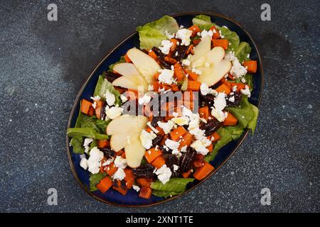 Insalata fresca a base di patate dolci al forno, mele fresche, pecan e feta, lattuga. Foto Stock