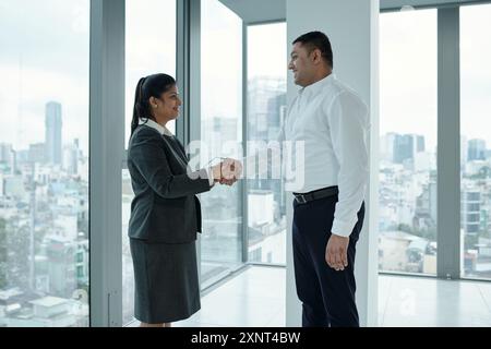 Colleghi che stringono la mano alla riunione Foto Stock