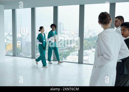 Gruppo di medici che camminano lungo il corridoio Foto Stock