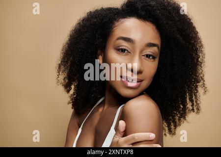 Un ritratto ravvicinato di una bella donna afroamericana con trucco naturale, sorridente dolcemente. Foto Stock