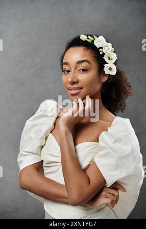 Una splendida sposa afroamericana indossa un abito da sposa bianco con fiori nei capelli. Foto Stock