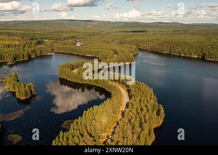 Foto aerea di una tortuosa strada asfaltata attraverso un esker in un lago di Dalarna, Svezia. Foto Stock