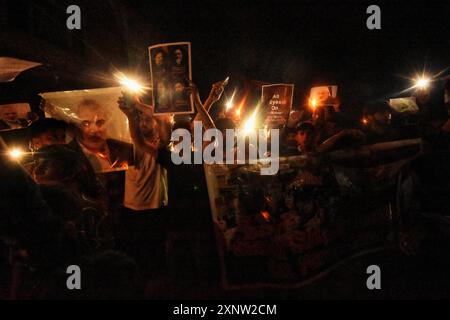 I musulmani sciiti del Kashmir tengono candele e cartelli mentre gridano slogan pro-Palestina e anti-Israele durante una manifestazione a lume di candela. Un raduno a lume di candela si è tenuto alla periferia di Srinagar in seguito all'assassinio di Ismail Haniya, uno dei principali leader politici di Hamas, ucciso a Teheran, la capitale dell'Iran. Sia l'Iran che Hamas hanno incolpato Israele per l'assassinio. I manifestanti hanno espresso solidarietà alle comunità colpite, condannando la violenza e chiedendo giustizia e la fine degli attacchi settari. (Foto di Mubashir Hassan/Pacific Press) Foto Stock