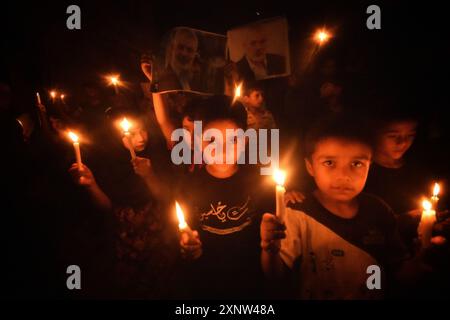 Srinagar, Jammu e Kashmir, India. 1 agosto 2024. I musulmani sciiti del Kashmir tengono candele e cartelli mentre gridano slogan pro-Palestina e anti-Israele durante una manifestazione a lume di candela. Un raduno a lume di candela si è tenuto alla periferia di Srinagar in seguito all'assassinio di Ismail Haniya, uno dei principali leader politici di Hamas, ucciso a Teheran, la capitale dell'Iran. Sia l'Iran che Hamas hanno incolpato Israele per l'assassinio. I manifestanti hanno espresso solidarietà alle comunità colpite, condannando la violenza e chiedendo giustizia e la fine degli attacchi settari. ( Foto Stock