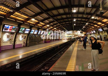 Passeggeri giapponesi viaggiatori in attesa di viaggio locomotiva linea Enoshima Dentetsu o treno Enoden alla stazione di Fujisawa per una visita a Kamakura Foto Stock