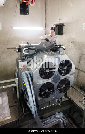 PRODUZIONE - 31 luglio 2024, Assia, Francoforte/M.: Markus Zink, tecnico di assistenza presso Schindler, lavora su un ascensore nella sala macchine. Il produttore di ascensori Schindler testa vari componenti dei suoi ascensori nell'Europaturm, la torre televisiva di Francoforte. Foto: Lando Hass/dpa Credit: dpa Picture Alliance/Alamy Live News Foto Stock