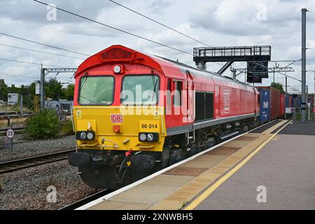 Il diesel DB classe 66 conduce il treno di container a sud attraverso Peterborough, Cambridgeshire, Inghilterra, Regno Unito Foto Stock