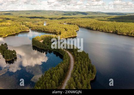 Foto aerea di una tortuosa strada asfaltata attraverso un esker in un lago di Dalarna, Svezia. Foto Stock