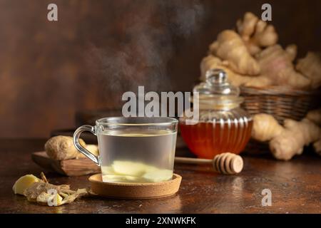 Tè allo zenzero con miele su sfondo marrone. Foto Stock