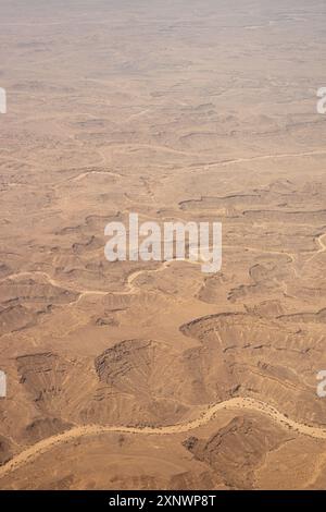 Un'accattivante vista aerea del paesaggio roccioso del deserto in Oman, che mostra terreno accidentato e letti di fiumi asciutti e tortuosi. Questa immagine funge da metafora per i colpi di scena della vita. Foto Stock