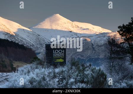 Loch Lomond and Trossachs National Park Signboard with Ben More and the Crianlarich Hills behind in winter, Loch Lomond and Trossachs National Park, Scottish Highlands, Scotland Foto Stock