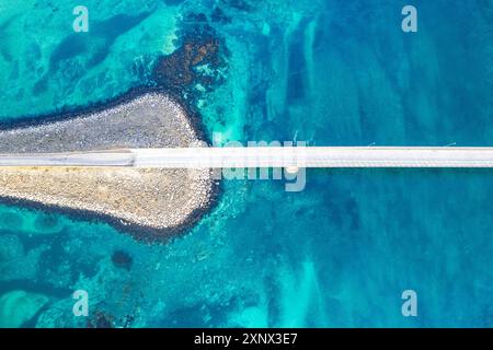 Vista aerea del ponte che collega le isole che attraversano il fiordo con acque turchesi dell'Artico, Flakstadburene, Fredvang, Isole Lofoten, Norvegia Foto Stock