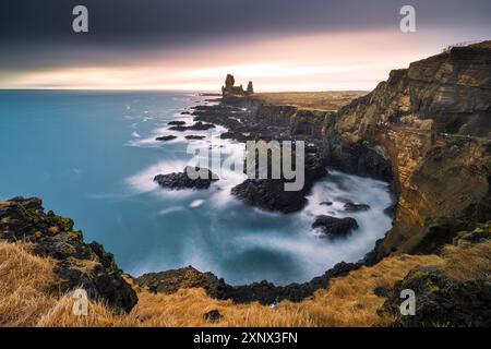 La splendida scogliera basaltica di Londrangar, fatta con una lunga esposizione in una fredda giornata invernale, Islanda, regioni polari Foto Stock