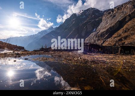 I pendii di montagna si riflettono in una pozza d'acqua nei campi agricoli, villaggio di Lang Tang, Himalaya, Nepal, Asia Foto Stock